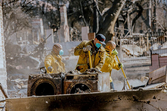 People cleaning up a burned down house after the Los Angeles Fires